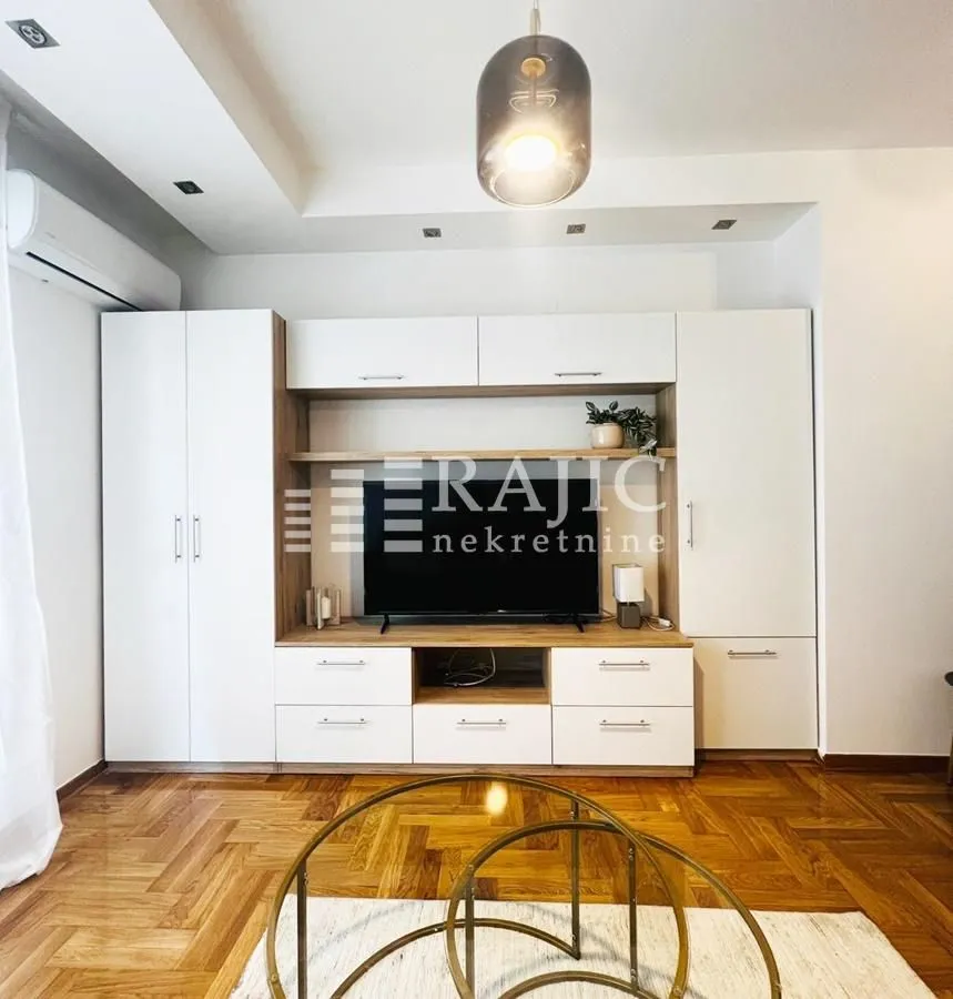 Living room with a TV unit and parquet flooring.