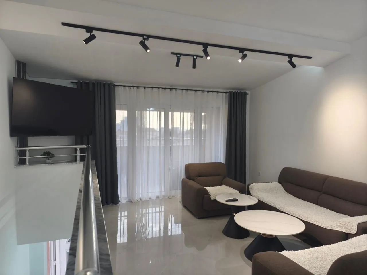 Living room with sofa set, coffee tables, and TV.
