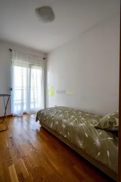 Smaller bedroom with a bed and balcony doors. - image 20