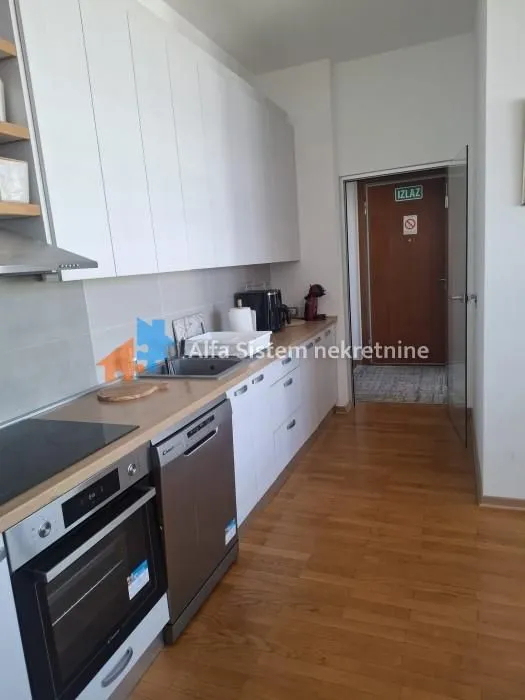 Modern kitchen with white cabinetry and built-in appliances.