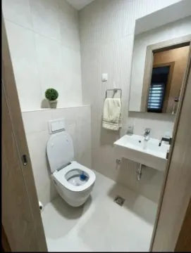 Small bathroom with a toilet, washbasin, and mirror. - image 7