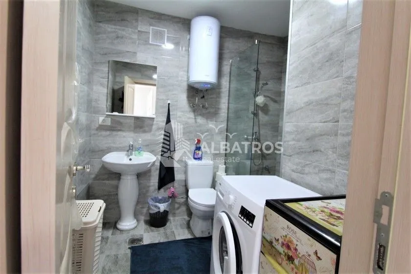 Bathroom equipped with sanitary ware, a shower cabin, and a washing machine.
