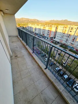 Dugi popločani balkon sa metalnom ogradom i pogledom na grad i planine. - image 15