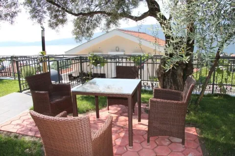 Baštenska garnitura sa stolom i stolicama u dvorištu kuće sa pogledom na more. - image 5