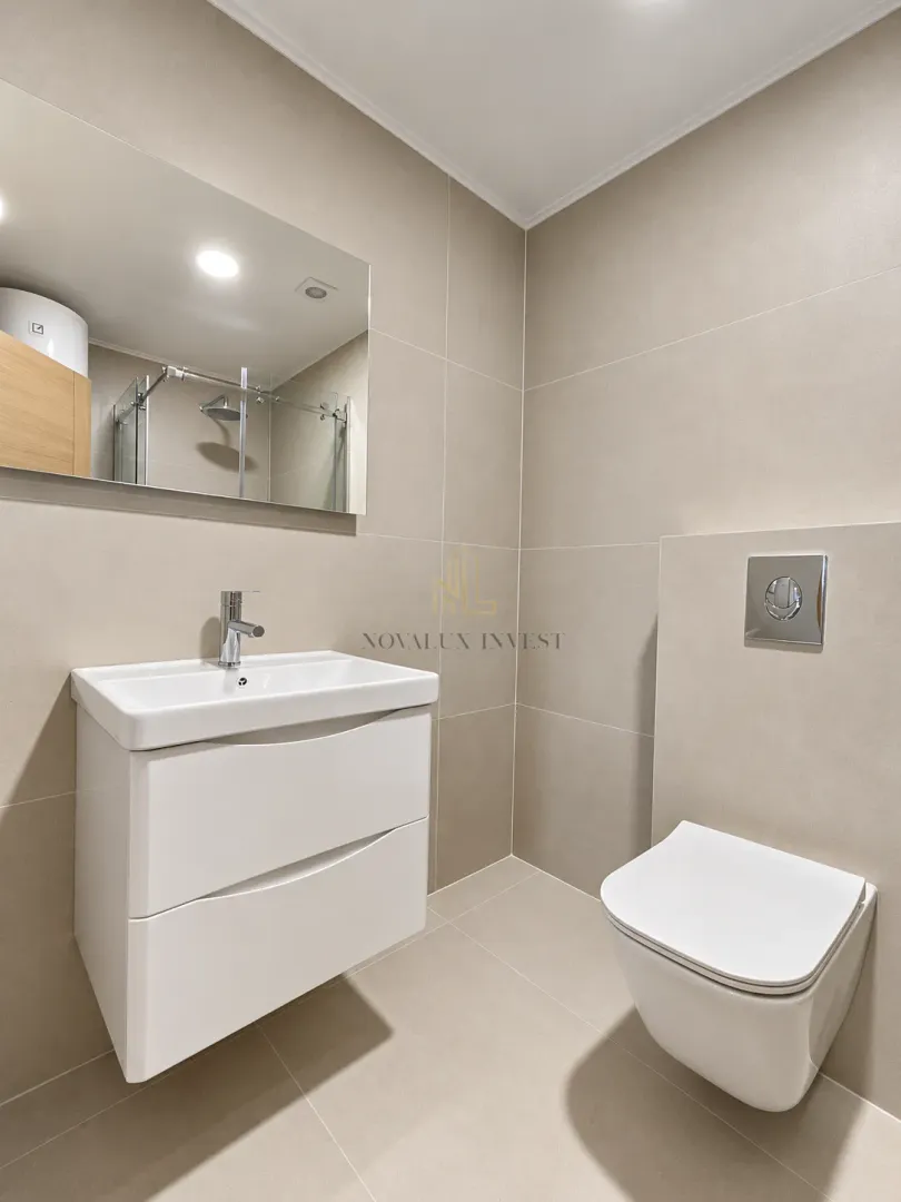 Modern equipped bathroom with a washbasin, mirror and wall-hung toilet.