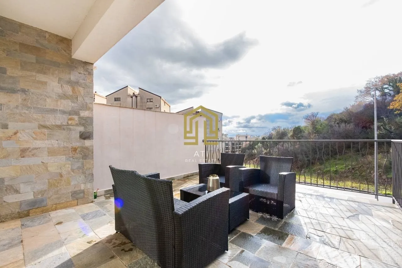 Spacious covered terrace with seating set and surrounding view.