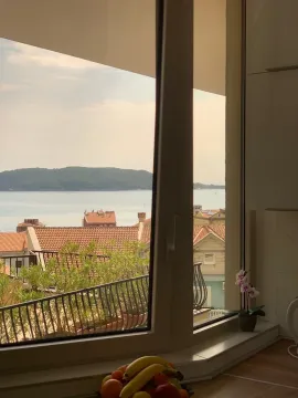 Pogled na more i krovove grada kroz prozor. - image 8