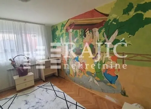 Children's bedroom with a wall mural and parquet flooring.