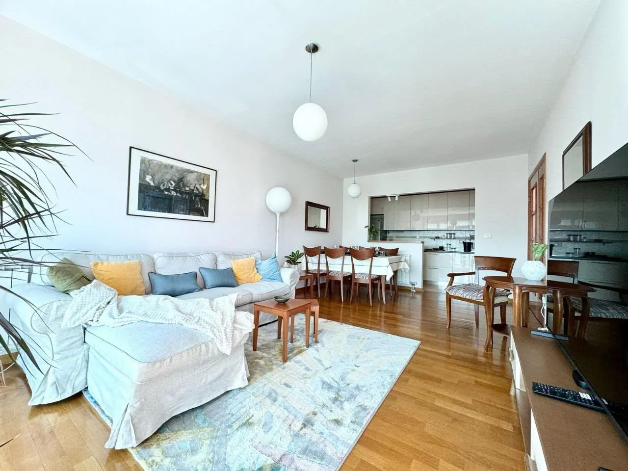 Spacious living room with a sofa set and a dining area in the background.