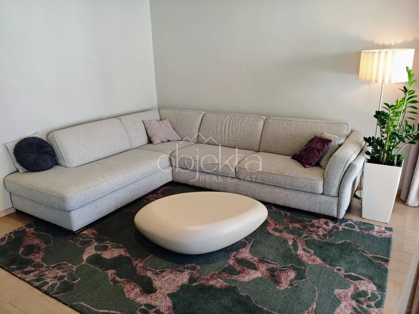 Living room with a sectional sofa, coffee table, and lamp.