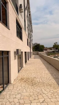 Exterior of the building with a paved courtyard and walkway. - image 2