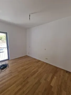 Empty room with wooden flooring and a balcony door. - image 8