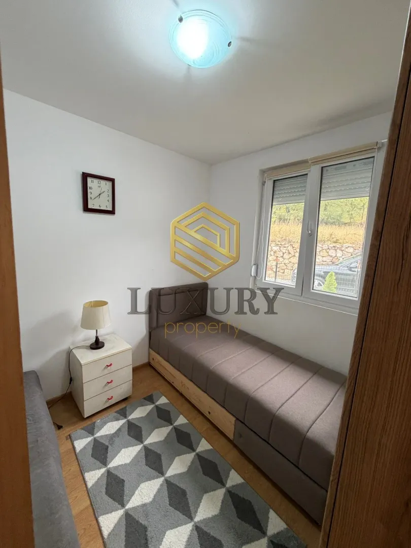 Smaller bedroom with a bed and a nightstand.