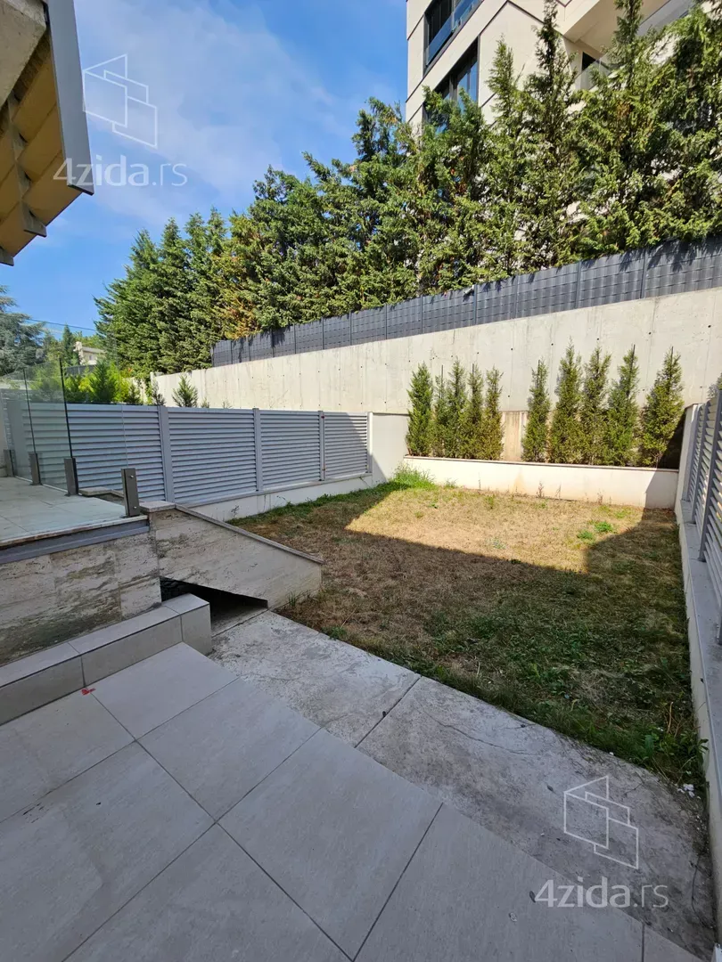 Private courtyard with a paved area and a lawn.