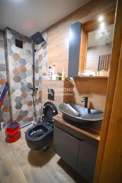 Moderno kupatilo sa tuš kabinom, crnom sanitarnom opremom i drvenim oblogama. - image 5