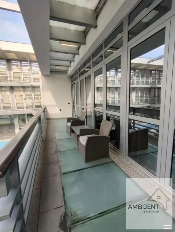 Spacious covered terrace with patio furniture and a view.