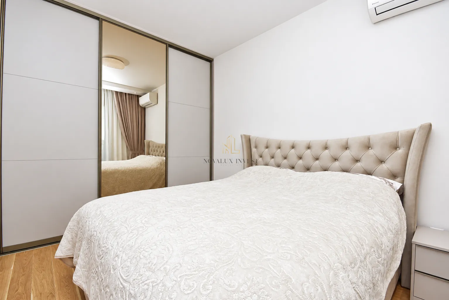 Bedroom with a double bed and a large fitted wardrobe with mirror.