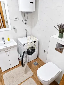 Bathroom equipped with a washbasin, toilet, washing machine, and water heater. - image 8