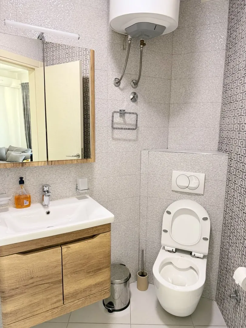 Small bathroom with a sink, toilet, and water heater.