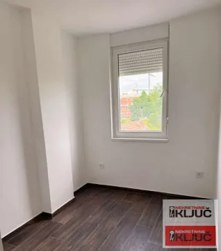 Prazna soba sa prozorom i tamnim drvenim podom. - image 8