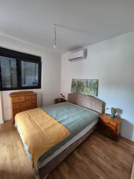 Furnished bedroom with a double bed, wooden dresser, and nightstands. - image 4