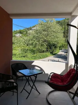 Namještena terasa sa stolom, stolicama i pogledom na prirodu i cestu. - image 16