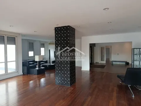 Spacious living room with wooden flooring and a central mosaic-tiled pillar. - image 14