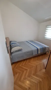 Small bedroom with a double bed and parquet flooring. - image 5