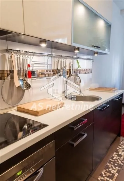 View of a modern equipped kitchen with work surfaces and built-in elements.