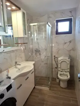 Bathroom with a shower cabin, washbasin, and installed toilet. - image 6