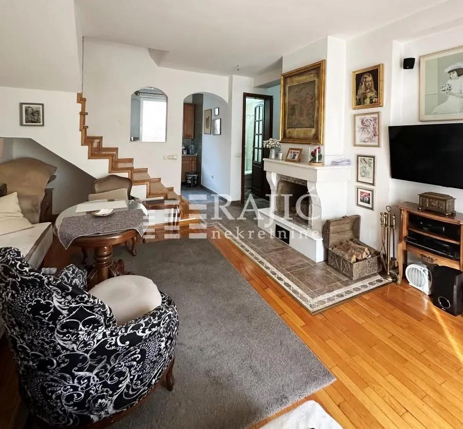 Spacious living room with a fireplace and staircase.