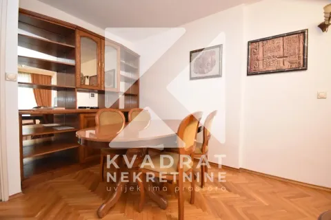Dining area with a wooden table, chairs, and a large wall display cabinet. - image 4