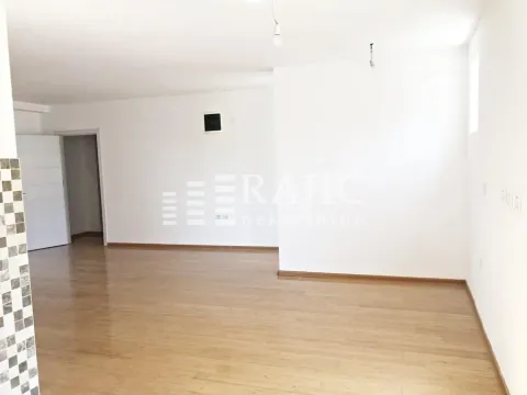 Prazna svetla prostorija sa parketom i belim zidovima. - image 2