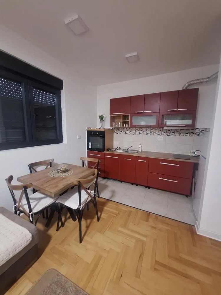 Kitchen with dining area and red wooden cabinets.