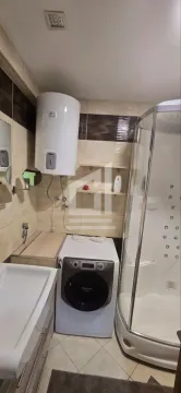 Bathroom equipped with a shower cabin, washbasin, washing machine, and water heater. - image 3
