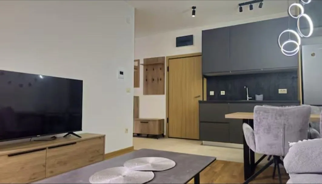 Modern living room with dining area and kitchen in the background.