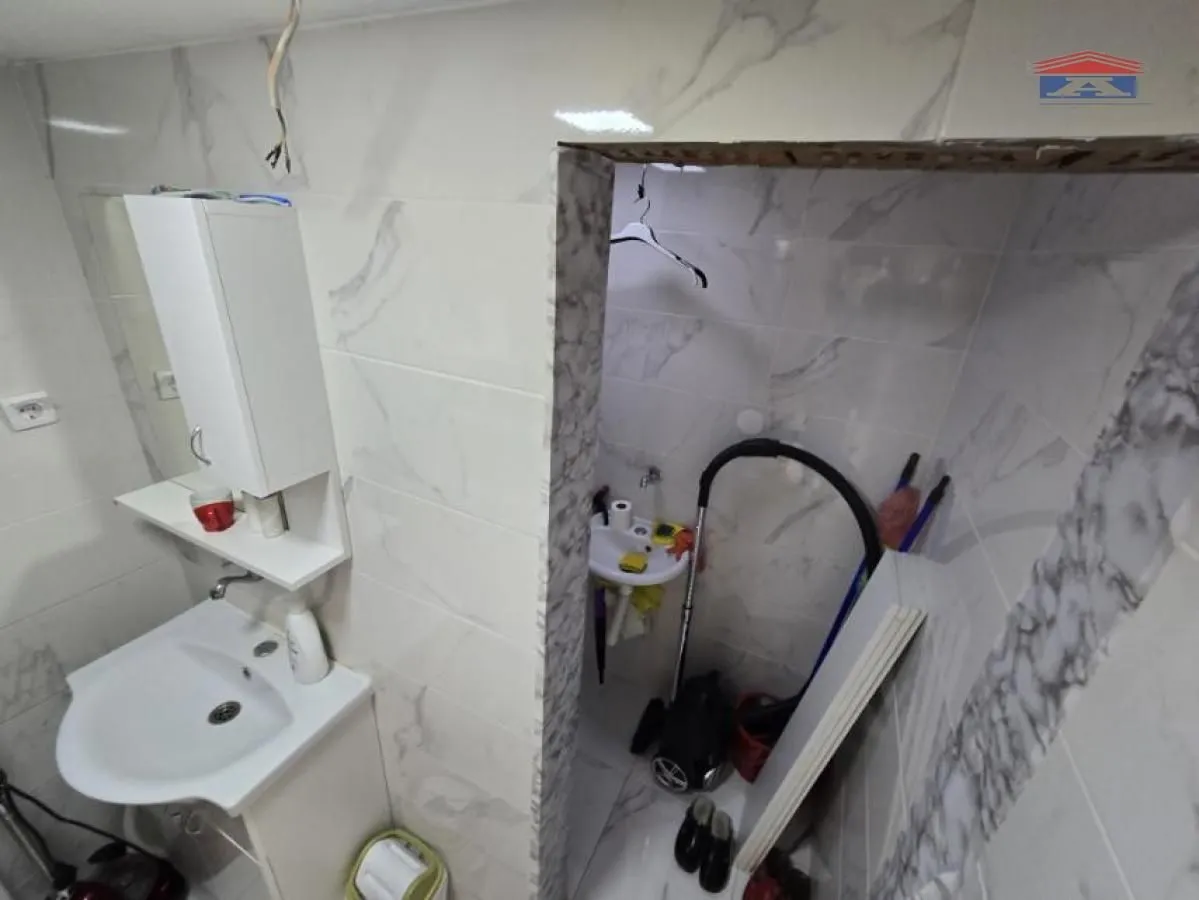 Small bathroom with a washbasin and tiles.