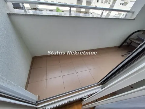 Manji popločani balkon sa metalnom ogradom i stolicom. - image 10