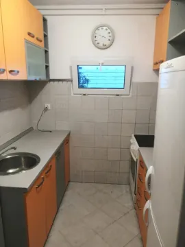 Small kitchen with orange cabinets and a sink. - image 7