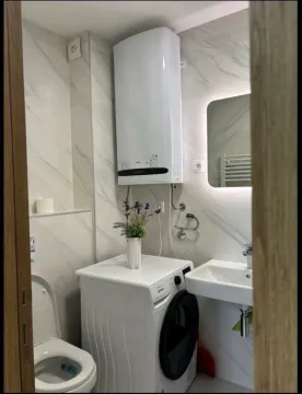 Manje kupatilo sa veš mašinom i bijelim sanitarijama. - image 7