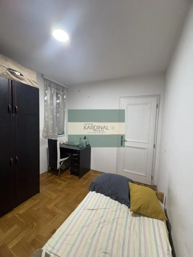 Small bedroom with a bed, wardrobe, and a desk.