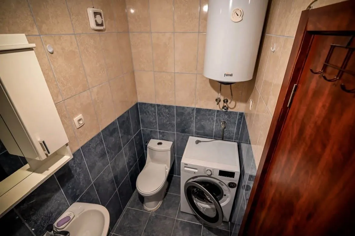 Manje kupatilo sa WC šoljom, bideom, veš mašinom i bojlerom.