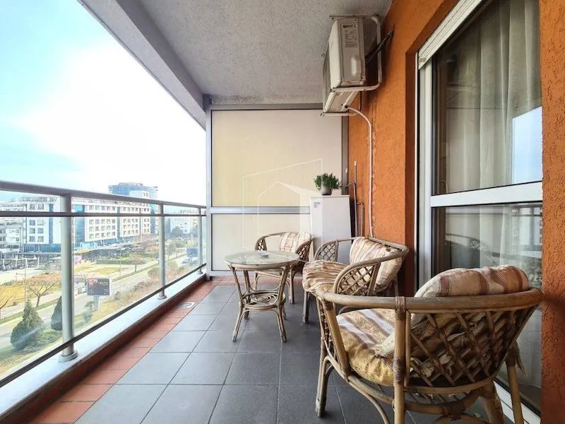 Spacious furnished terrace with seating furniture and city view.