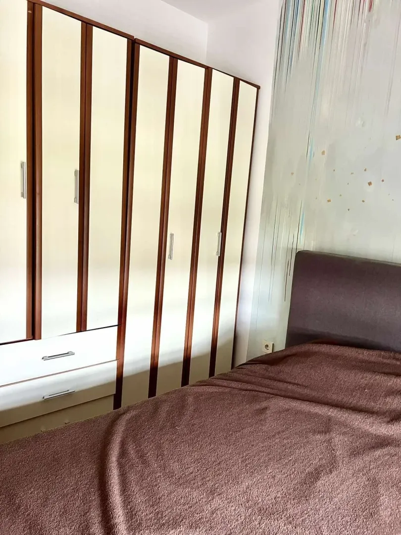 Spavaća soba sa velikim ugradnim plakarem i bračnim krevetom.