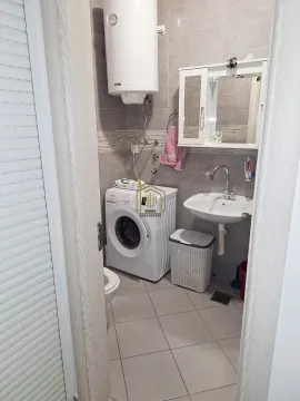 Pogled na kupatilo sa umivaonikom, veš mašinom i bojlerom. - image 6