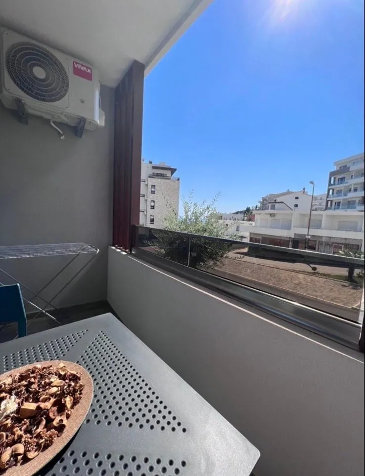 Manji namješteni balkon sa pogledom na okolne zgrade i ulicu.