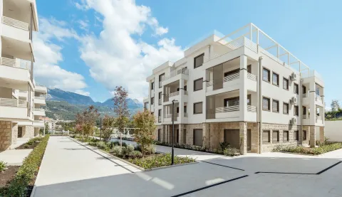 Eksterijer moderne stambene zgrade sa uređenim dvorištem i pogledom na planine. - image 9