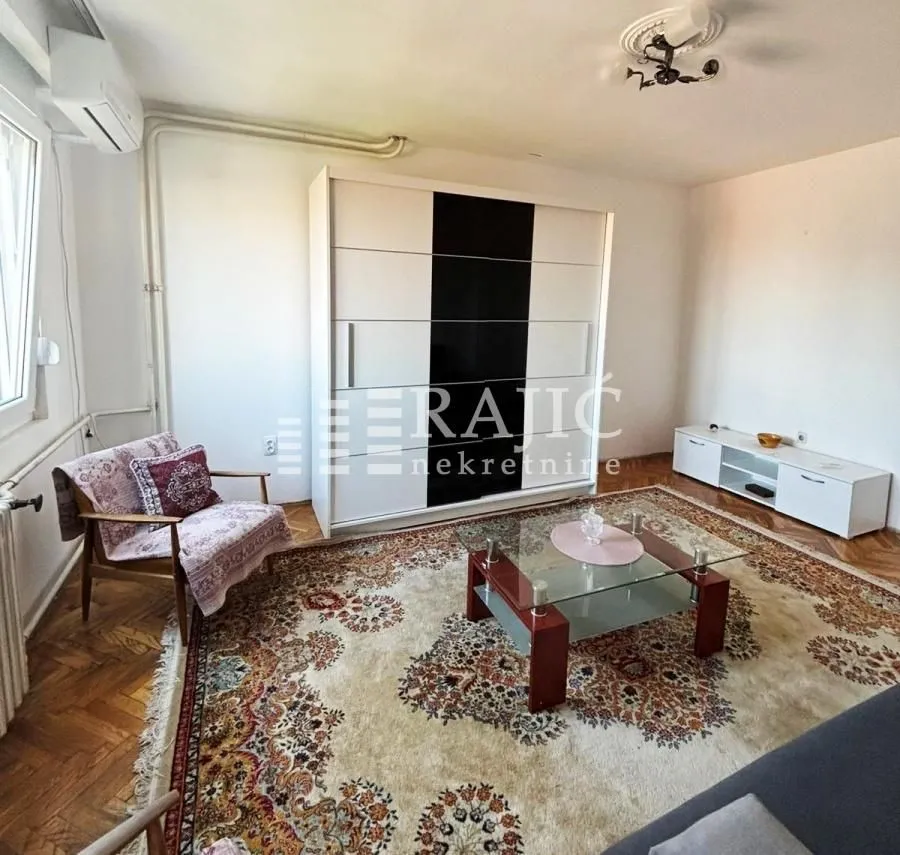 Living room with a sofa set, large wardrobe, and carpet.