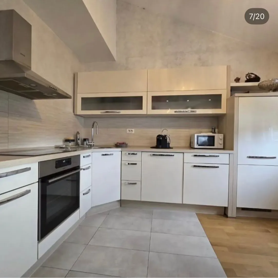 Modern kitchen with white cabinetry and built-in appliances.
