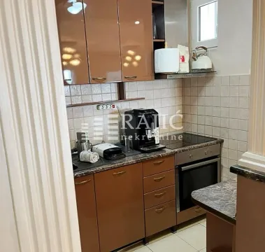 Small kitchen with brown cabinets and built-in appliances. - image 3